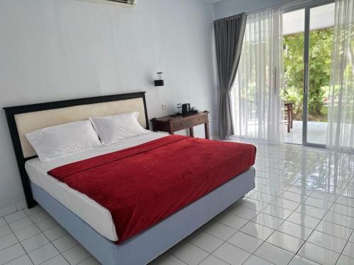 a bedroom with a bed with a red blanket at New Mekar Jaya Hotel in Legian