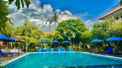 basen z niebieskimi leżakami i parasolami w obiekcie New Mekar Jaya Hotel w mieście Legian