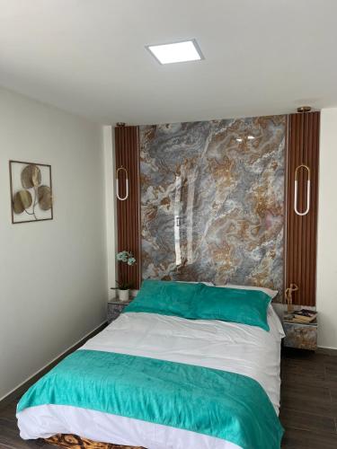 Suit Exclusiva y elegante في ريوبامبا: غرفة نوم بسرير اخضر وبيض مع جدار