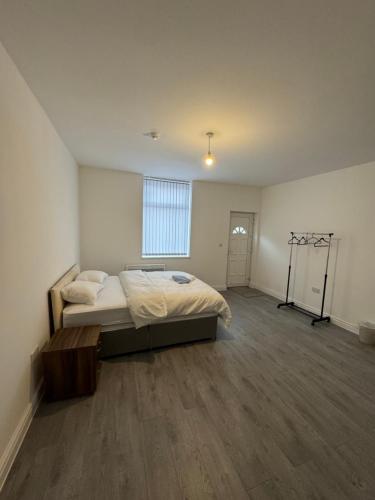 1 dormitorio grande con 1 cama y ventana grande en Chief Vic Guest house en Oldham