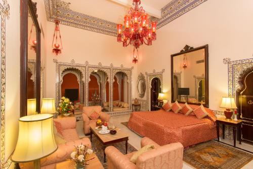 a bedroom with a bed and a living room at Shiv Niwas Palace by HRH Group of Hotels in Udaipur
