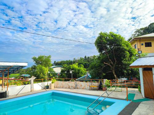 a swimming pool in a house with a sky at Juanito's Resort in Tangalan