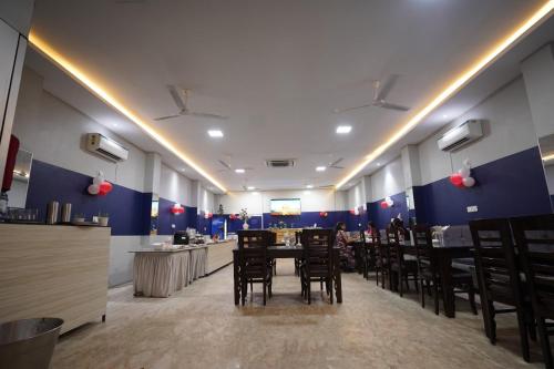 Prayagraj的住宿－Temptation Classio，一间配备有桌椅的用餐室和蓝色的墙壁