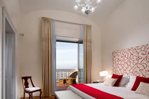 a bedroom with a bed and a view of a balcony at Grand Hotel Excelsior Vittoria in Sorrento