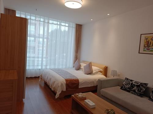 een hotelkamer met een bed en een bank bij Changchun Clear Moon Apartment by South Lake Hotel in Changchun