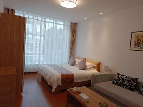 a hotel room with a bed and a couch at Changchun Clear Moon Apartment by South Lake Hotel in Changchun