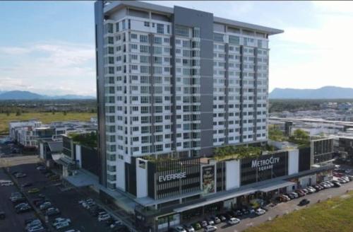 uma vista superior de um grande edifício com um parque de estacionamento em D&Q METROCITY GUESTHOUSE em Kuching