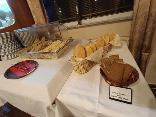 a table with baskets of bread and baskets of pastries at Hotel Razgorsek in Velenje