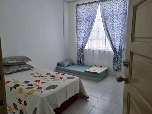 a bedroom with a bed and a window at Big Homestay For Big Family 2 With Wi fi in Sungai Petani