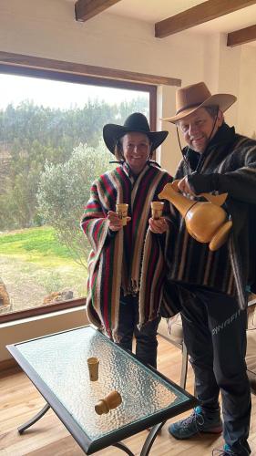 two men standing next to a table with cups on it at Steingarten, Casa de Campo hermosa y amoblada. in Riobamba