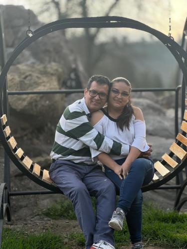 a man and a woman sitting on a swing at Steingarten, Casa de Campo hermosa y amoblada. in Riobamba