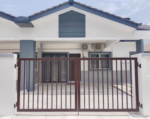 a house with a gate in front of it at UR Homestay, Seri Iskandar in Seri Iskandar
