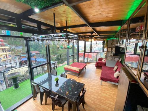 a living room with a table and chairs and windows at Holyghost Veranda Baguio Transient Guest House 42 step rooftop in Baguio