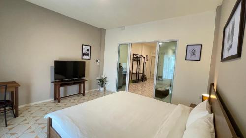 - une chambre avec un lit et une télévision à écran plat dans l'établissement Ay’s House, à Chiang Mai