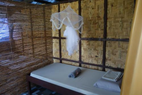 a room with a bed in a straw hut at Mi Casa Suites Siargao in General Luna