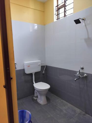 a bathroom with a white toilet and a sink at Edward's Home Stay in Sriperumbudur