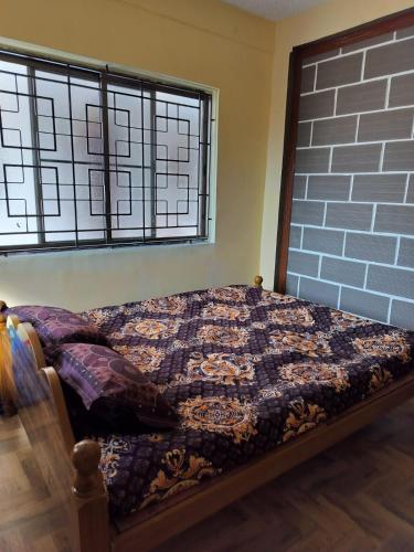 a bed in a room with two windows at Edward's Home Stay in Sriperumbudur