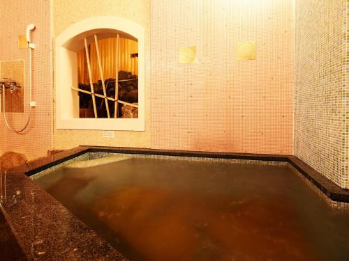 a pool of water in a bathroom with a mirror at Taikyourou in Miyazu