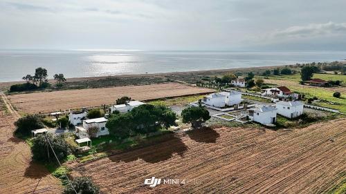 an aerial view of a farm next to the ocean at Boho Natural Beachfront Detached House in Análipsis