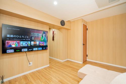 a living room with a flat screen tv on a wall at Sakura Suite in Tokyo