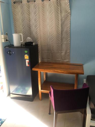 World Citizen GuestHouse في كو بانغان: طاولة خشبية وكرسي في الغرفة