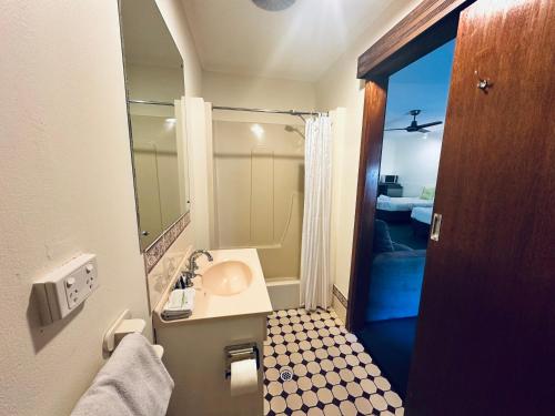 a bathroom with a sink and a mirror at Beachport Motor Inn in Beachport