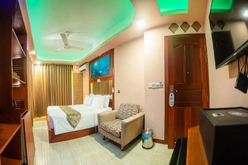 a hotel room with a bed and a chair at ZAN Lodge in Male City