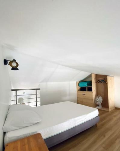 une chambre avec un lit blanc et une table dans l'établissement L'Embellie au coeur du village de La Cotinière, à La Cotinière