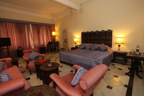 a large hotel room with a bed and chairs at Shiv Niwas Palace by HRH Group of Hotels in Udaipur