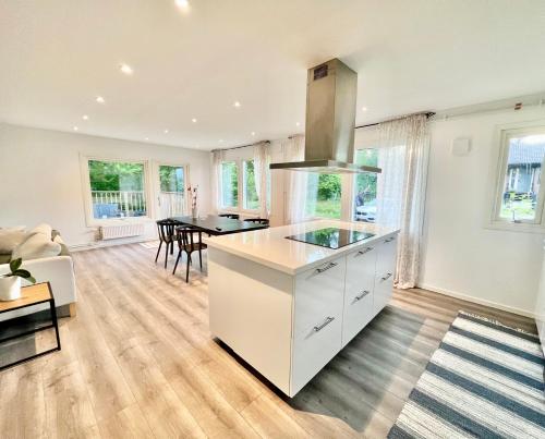 a kitchen with white cabinets and a dining room at Villa Kosta in Kosta