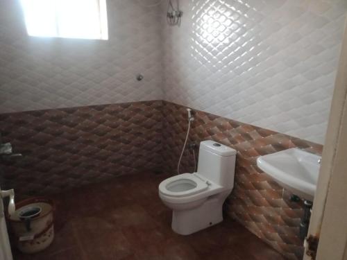 Suman beach House في تشيناي: حمام به مرحاض أبيض ومغسلة