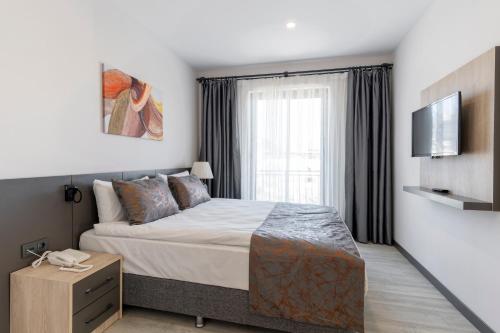 a bedroom with a large bed and a television at IRENIC HOTEL in Antalya