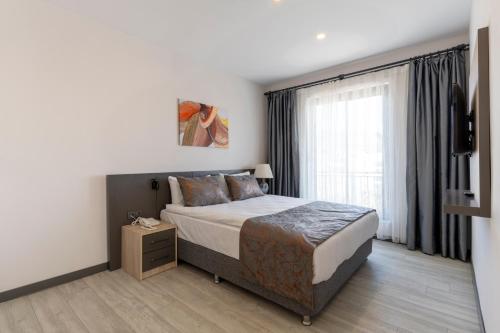 a bedroom with a bed and a large window at IRENIC HOTEL in Antalya