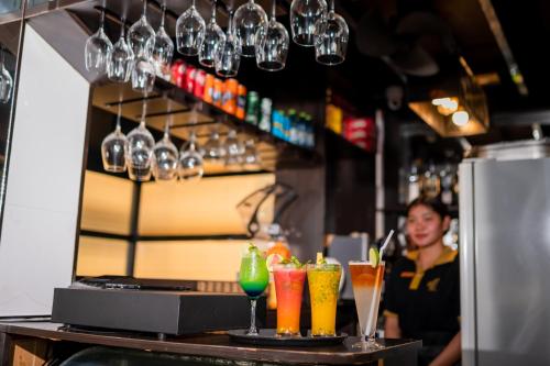 a bartender behind a bar with some drinks at ZAN Lodge in Male City