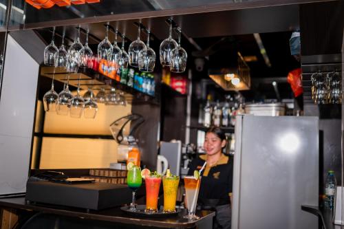 a woman standing behind a bar with some drinks at ZAN Lodge in Male City