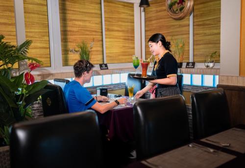 a woman and a man sitting at a table in a restaurant at ZAN Lodge in Male City