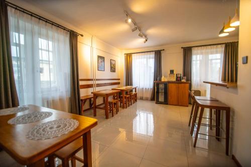 uma sala de estar com mesas, cadeiras e janelas em Zaya Hostel em Ulan Bator