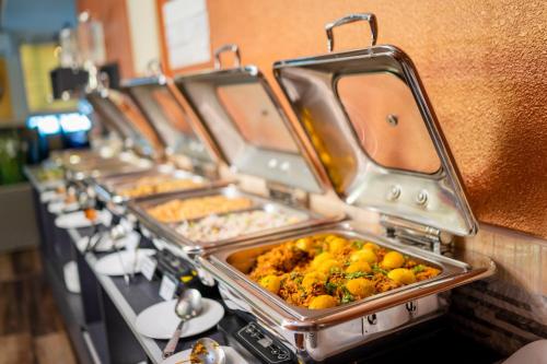 a row of trays of food on a buffet line at ZAN Lodge in Male City