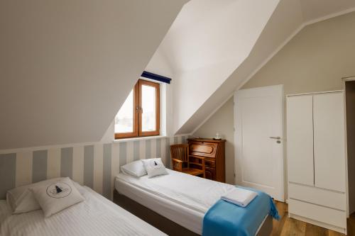 a bedroom with two beds and a desk and a window at Czar Mamry Apartamenty in Węgorzewo
