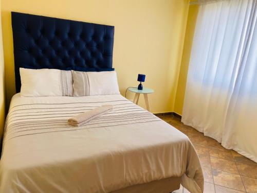 a bedroom with a large bed with a blue headboard at Third Haven in Swakopmund