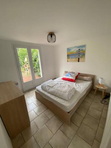 une chambre avec un lit dans une pièce dans l'établissement Maison de vacances, à La Cotinière