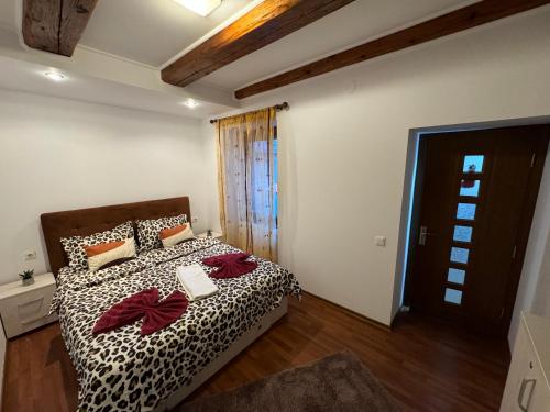 a bedroom with a bed with a black and white comforter at IaZi Apartament in Braşov