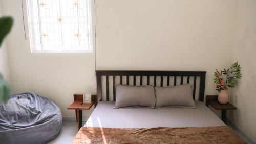 een bed met 2 kussens en een raam in een kamer bij Vit-dong Room - Room 2 Person - Duck Homestay Ben Tre in Ấp Phú Lợi