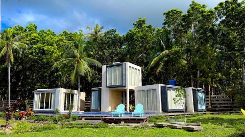 a house with blue chairs in front of it at The LivingSpace Villa in Camotes Islands
