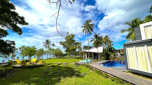 a backyard with a swimming pool and a house at The LivingSpace Villa in Camotes Islands