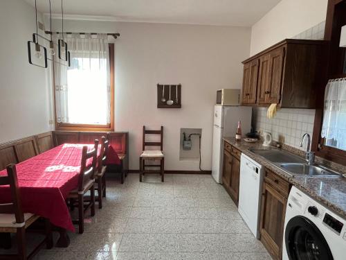 a kitchen with a table with a red table cloth at Casa Vacanze Lido Di Venezia in Venice-Lido