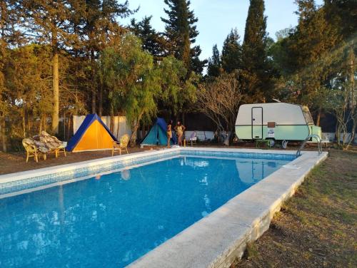 una piscina con una caravana y tiendas de campaña en Casa del Buho en Chiclana de la Frontera