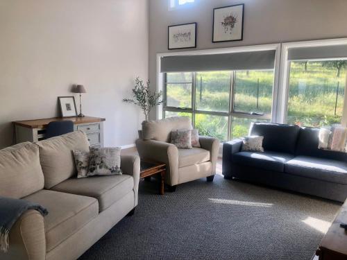 una sala de estar con un sofá y una silla en Danara Cottage, en Bathurst