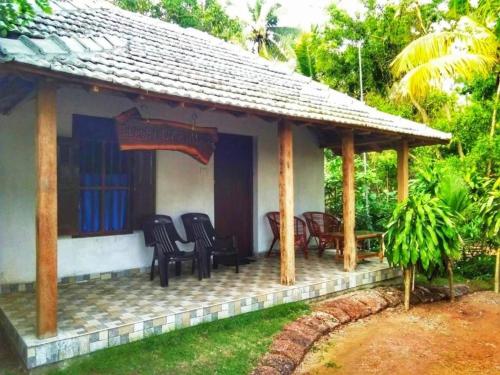 a small house with chairs and a porch at Beach Island Villas in Kollam