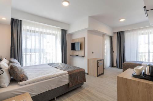 ein Hotelzimmer mit 2 Betten und einem TV in der Unterkunft IRENIC HOTEL in Antalya